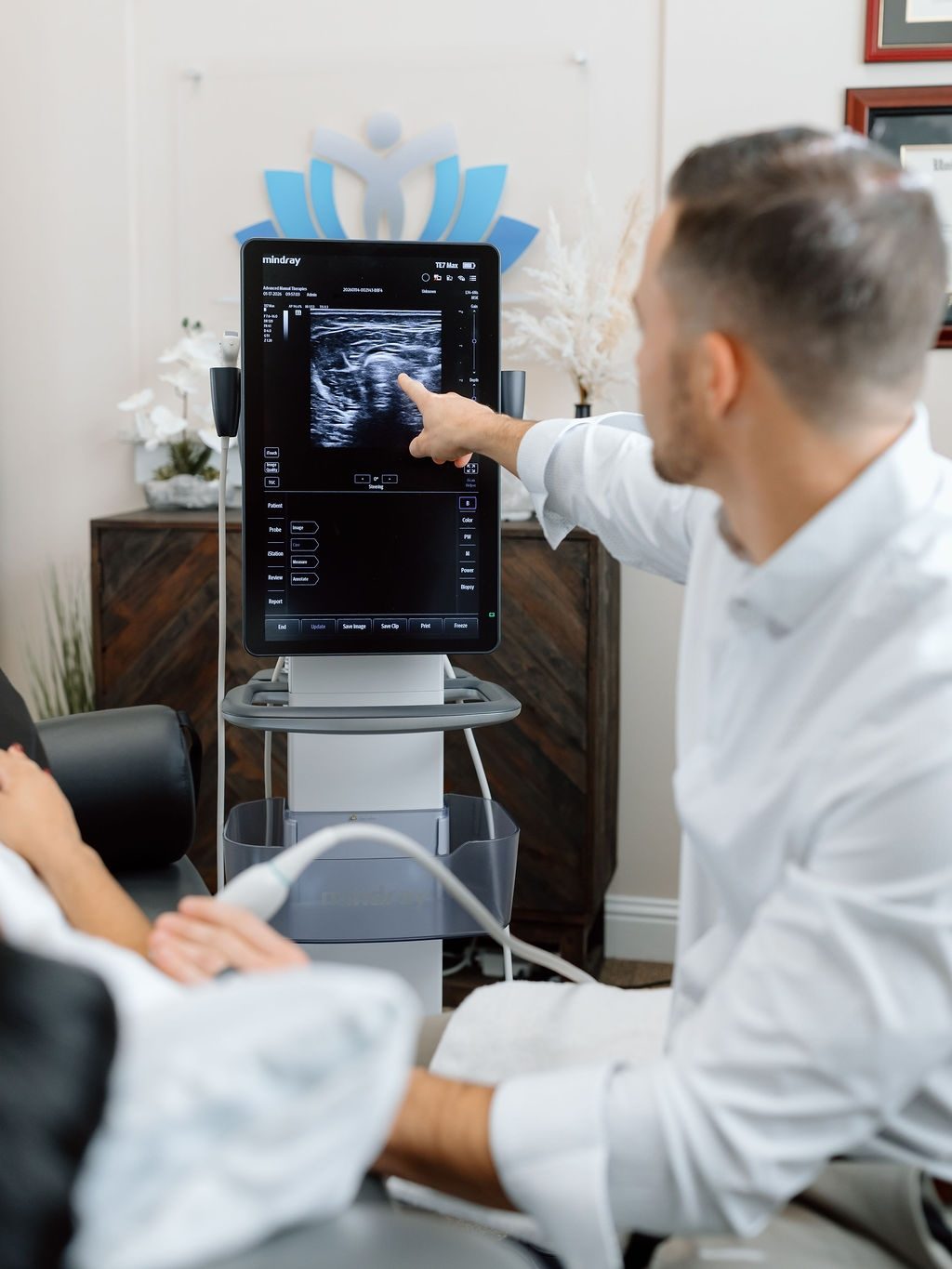 Dr. Grant Smith performing diagnostic ultrasound imaging at Tidal Wave Wellness in Alpharetta, Georgia
